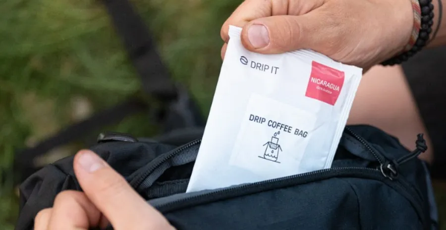 muž vkládá jeden filtr s kávou dripit do batohu