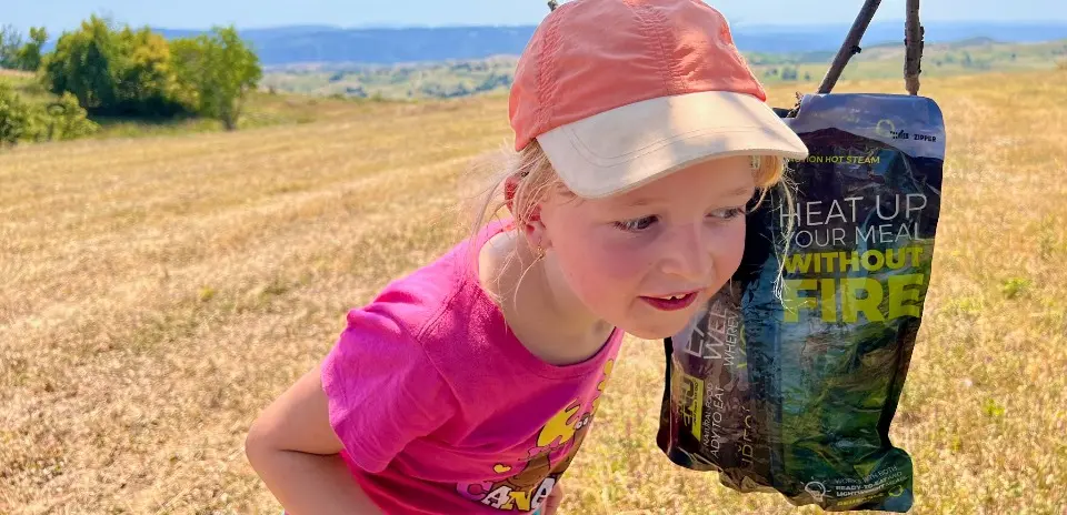 holčička pozoruje, jak se ohřívá sterilované jídlo adventure menu v zipper bagu