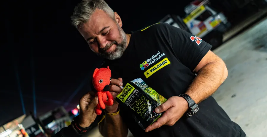 závodník Rallye Dakar jí ve stoje hotové jídlo adventure menu přímo ze sáčku