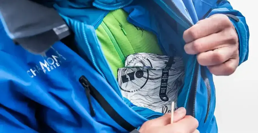 muž ukazuje sáček s jídlem ukrytý pod bundou