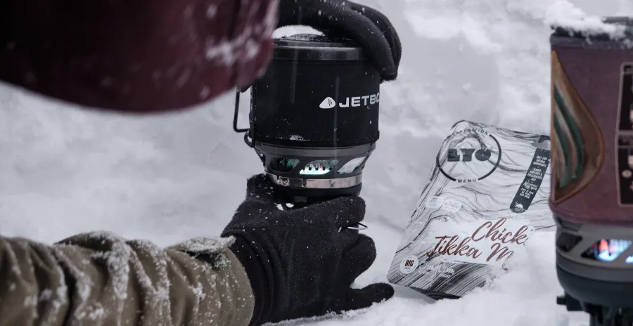 muž na sněhu zapaluje proudový vařič jetboil