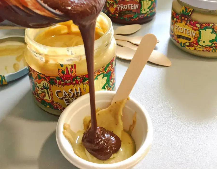 muž nalévá belgickou čokoládu do 100% ořechového másla