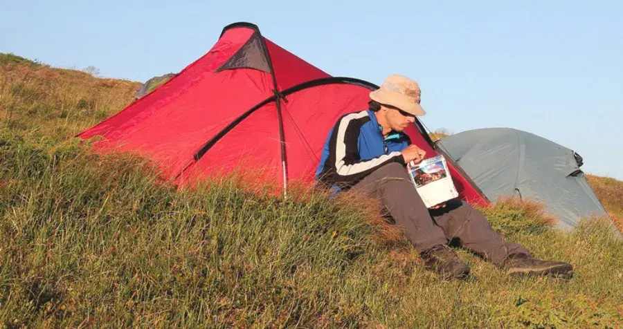 Arnošt Valach jí expediční stravu ze sáčku u stanu v přírodě