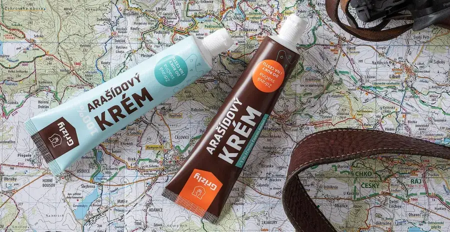 dva ořechové krémy Grizly v plastové tubě leží na stole na mapě světa