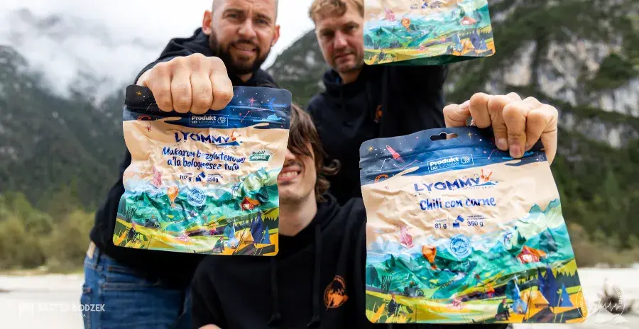 tři muži v horách drží v ruce sáčky s mrazem sušeným jídlem lyommy